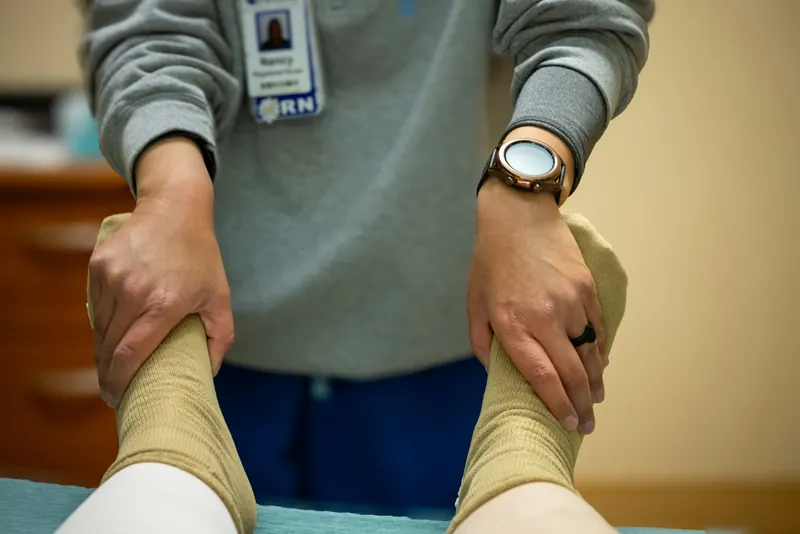 Clinician holding a client’s ankles during a lower-leg movement assessment